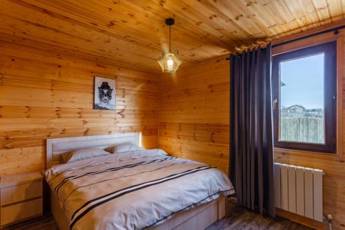 a bedroom with a bed in a log cabin at Eco house villa jeo in Tbilisi City