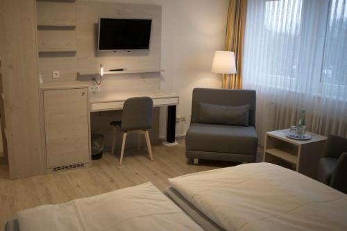a hotel room with a bed and a desk and a chair at Hotel Am Friesenstrand in Butjadingen