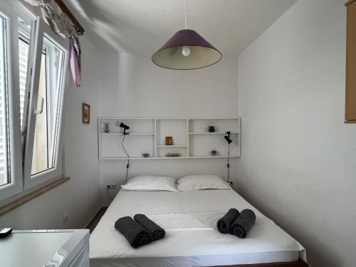 a bedroom with a white bed with two pillows on it at Apartman Blaga in Povlja