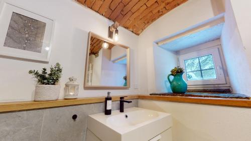 a bathroom with a sink and a mirror and a window at Romantická chalupa s krbem in Hořice na Šumavě