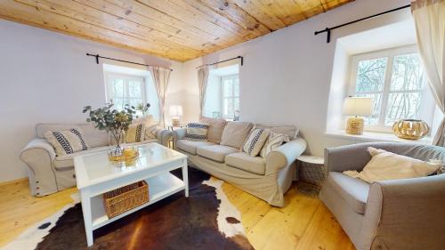 a living room with two couches and a table at Romantická chalupa s krbem in Hořice na Šumavě