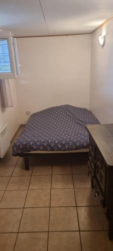 a small bed in a room with a table at Hote du Lion in Saint-Genis-Pouilly