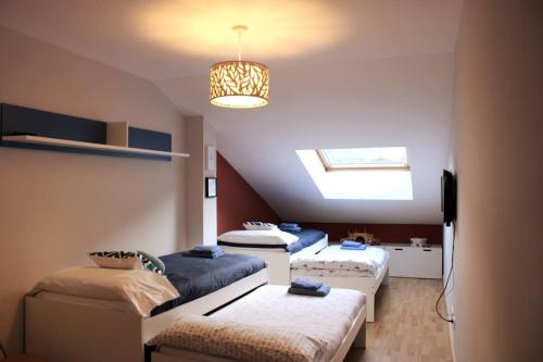 Habitación con 3 camas y lámpara de araña. en Precioso duplex en arbucias en Arbúcies