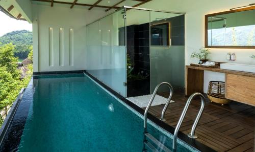 a bathroom with a swimming pool with a shower and a sink at MOUNTAIN SHADOWS RESORT Wayanad in Wayanad