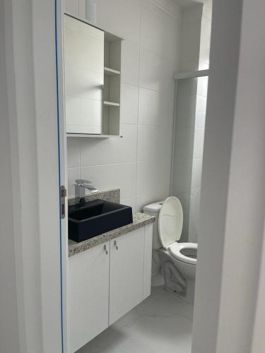 Baño blanco con lavabo y aseo en Belissimo apto Ingleses, en Florianópolis