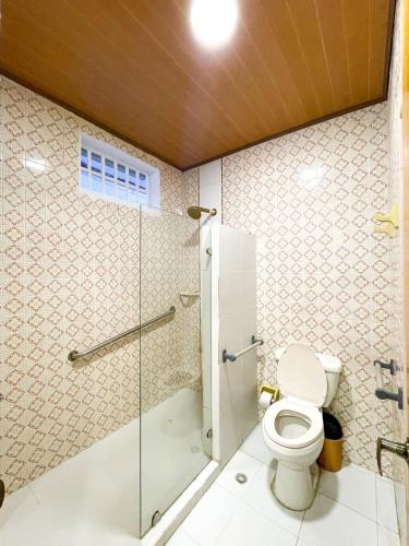 a bathroom with a toilet and a glass shower at Puesta del Sol Guest House in San Andrés
