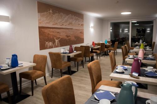 a dining room filled with tables and chairs at Hotel Am Friesenstrand in Butjadingen