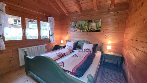 a bedroom with a bed in a wooden cabin at Ferienhaus Chalet Blockhaus Bayern in Stamsried