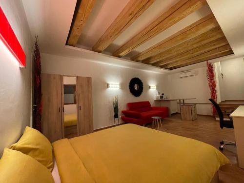 a bedroom with a yellow bed and a red couch at NEW Workspace Studio Savoya9 Self Check in Old City Center in Timişoara