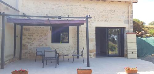 a patio with chairs and a table in front of a building at L orchidée in Saint-Martin-de-Saint-Maixent