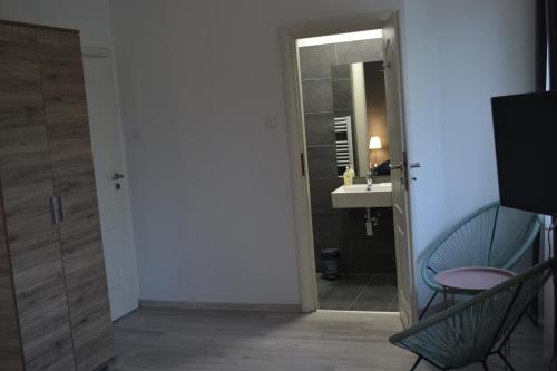 a bathroom with a door and a sink and a mirror at Főnix Design Rooms in Debrecen