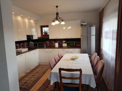 a kitchen with a table with chairs and a refrigerator at Visoko Homestay in Visoko