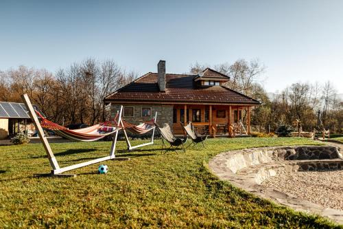 a house with two hammocks and a house at Atelier Recreation Village in Râşnov