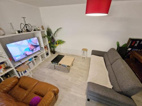 - un salon avec un canapé et une télévision dans l'établissement Chambre privée dans Happy Home Maison Calme Chez l'habitant, à Brest