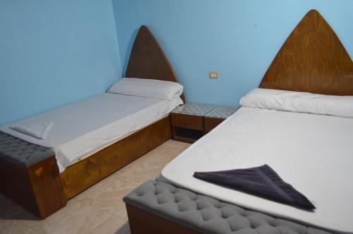 um quarto com duas camas e um banco em Golden nubian guesthouse em Aswan