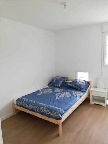 une chambre avec un lit avec une couette bleue dans l'établissement Chambre privée dans Happy Home Maison Calme Chez l'habitant, à Brest