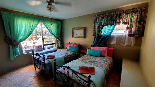 1 Schlafzimmer mit 2 Betten und einem Fenster in der Unterkunft Tiny's Getaway in Jeffreys Bay