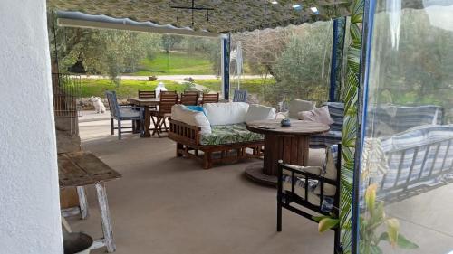 eine Terrasse mit einem Sofa, einem Tisch und Stühlen in der Unterkunft Vivienda rural del salado in Jaén