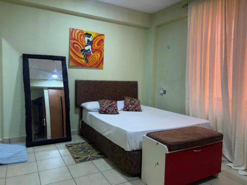 a bedroom with a large bed with a mirror at Eunice cosy aboard in Kilifi
