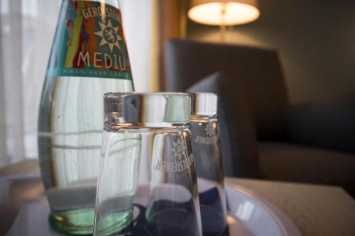 a bottle and two glass vases on a table at Hotel Am Friesenstrand in Butjadingen