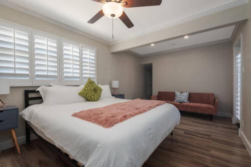 a bedroom with a large bed with a ceiling fan at The Pink Cactus - Desert Retreat - Luxe Pool, Golf & Game Room in Indio