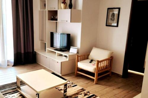 een woonkamer met een stoel en een televisie bij Appartamento moderno in posizione strategica in Sala Baganza