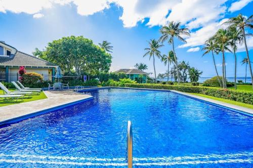 a swimming pool in a house with palm trees at Honu He'e Nalu - The Surfing Turtle - Ocean & Beachfront! Stunning Views! in Koloa