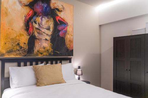 a bedroom with a bed with a painting on the wall at AN&VI Boutique Apartments Apt201 in Ioannina