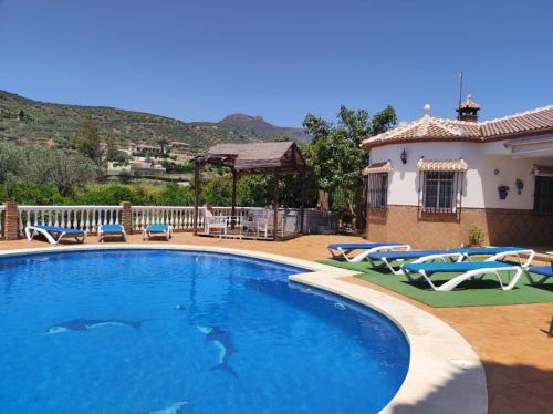una piscina con sillas y una casa en Los Naranjos, en Alcaucín