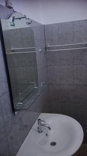 La salle de bains est pourvue d'un lavabo et d'une douche avec un miroir. dans l'établissement joli studio meuble 25 euro par nuit., à Lomé
