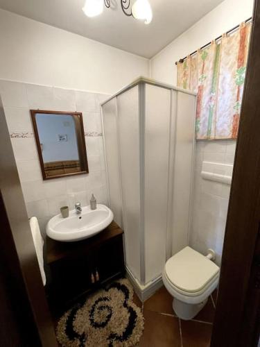 a white bathroom with a sink and a toilet at Taverna in Putignano
