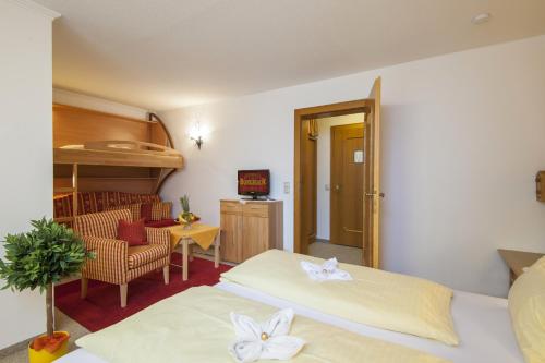 a room with two beds and a table and a chair at Hotel-Restaurant Burgblick in Dorfgastein