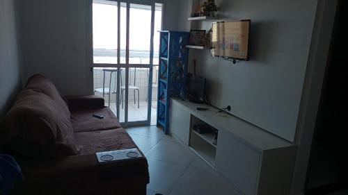 Una televisión o centro de entretenimiento en Apartamento Praia Grande Ocian