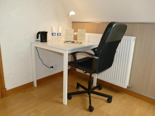 a white desk with a black chair in a room at Les Grands Crus - gîte "Meursault" in Corpeau
