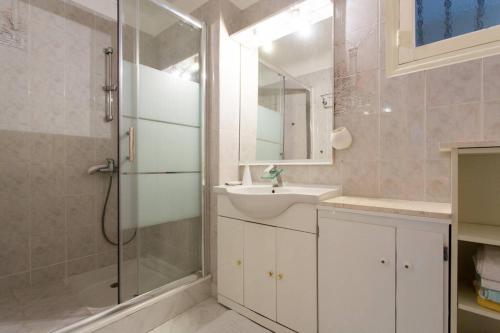 une salle de bain avec une douche, un lavabo et un miroir dans l'établissement Holiday or Congress, Centre - Beach, à Cannes