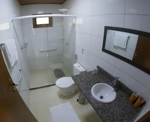 La salle de bains est pourvue d'un lavabo, de toilettes et d'une douche. dans l'établissement Chalé Vista da Mata DM, 5km Centro Domingos Martins, Wi Fi, fibra óptica, SPA aquecido, split, privacidade, aceita pets, à Domingos Martins