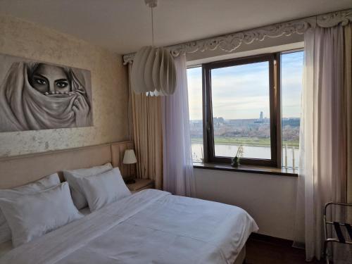 een slaapkamer met een bed en een groot raam bij Beograd na Vodi - BW ARCADIA LUXURY in Belgrado