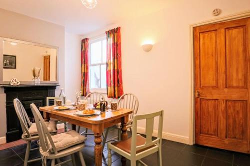 a dining room with a wooden table and chairs at Cute Cottage 5 min walk from Cafés Station and Sea in Hastings