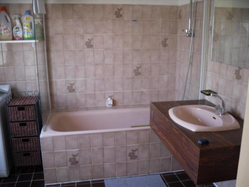 een badkamer met een bad en een wastafel bij Océan in Penmarcʼh