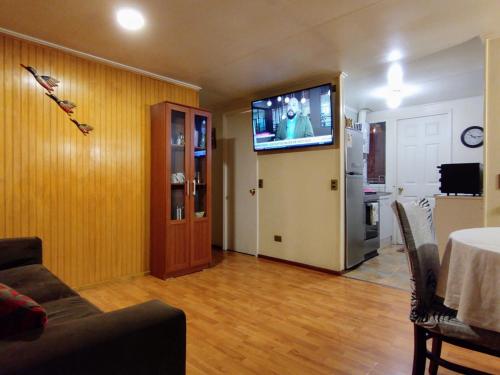 sala de estar con TV de pantalla plana en la pared en Cabaña en Puerto Montt, en Puerto Montt