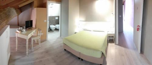 1 dormitorio con cama, escritorio y baño en Affittacamere ADELPHIA, en Guastalla