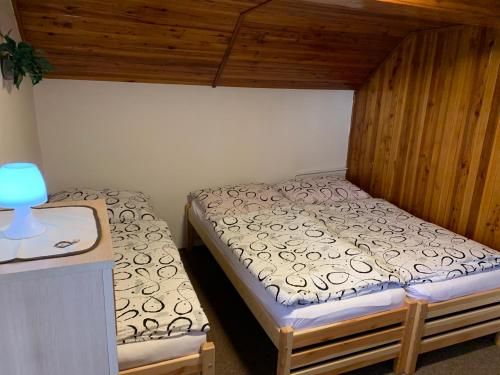 um pequeno quarto com uma cama e uma mesa em Chata Slunečná louka em Cerný Dul