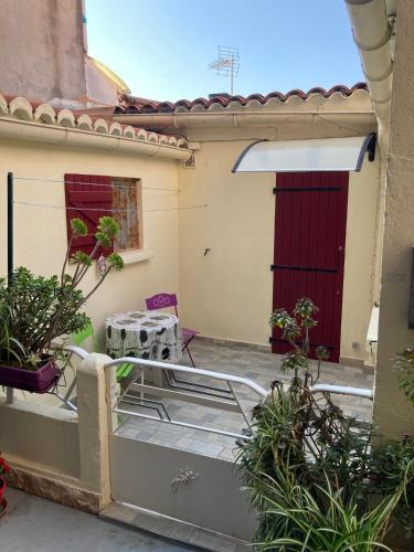 - une vue depuis l'extérieur d'une maison avec une porte rouge dans l'établissement T3 propriano pied dans l’eau, à Propriano