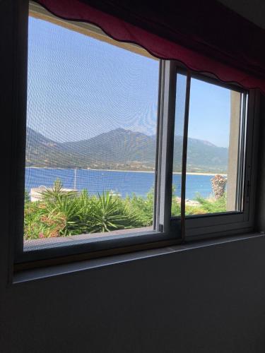 une fenêtre avec vue sur l'océan et les montagnes dans l'établissement T3 propriano pied dans l’eau, à Propriano