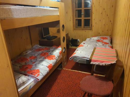 a bedroom with two bunk beds and a chair at Chata Božena - Čertovica in Jarabá
