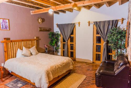 a bedroom with a bed and a chair in a room at Hotel Colibri in Mineral de Pozos