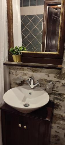 a white sink in a bathroom with a mirror at Αρχοντικό Ταξίμι (Μουντζουρίδη) in Argalasti