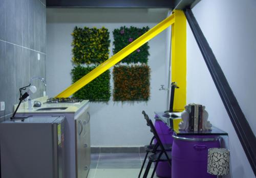 um quarto com uma linha amarela numa parede com uma mesa e cadeiras em Apartaestudio # 2 em Cali