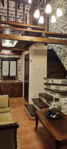 a living room with a staircase and a table at Αρχοντικό Ταξίμι (Μουντζουρίδη) in Argalasti
