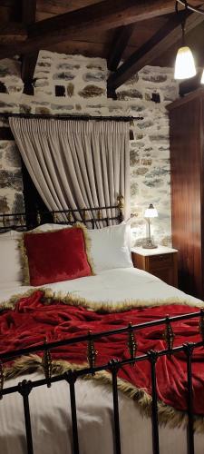 a bedroom with a bed with a stone wall at Αρχοντικό Ταξίμι (Μουντζουρίδη) in Argalasti